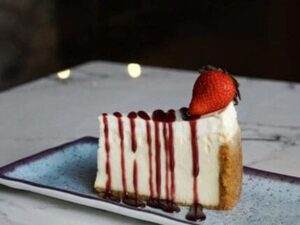 A piece of cake with strawberries on top.