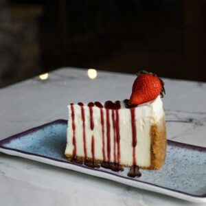 A piece of cake with strawberries on top.