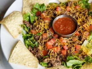A plate of food with tortilla chips and salsa.