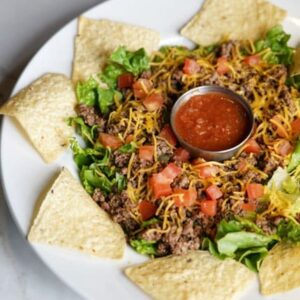 A plate of food with tortilla chips and salsa.